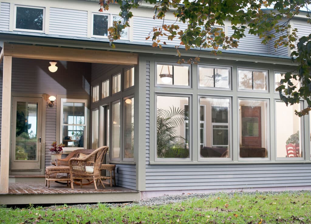 Modern porch with composite decking, white railing, and overhead pergola providing shade